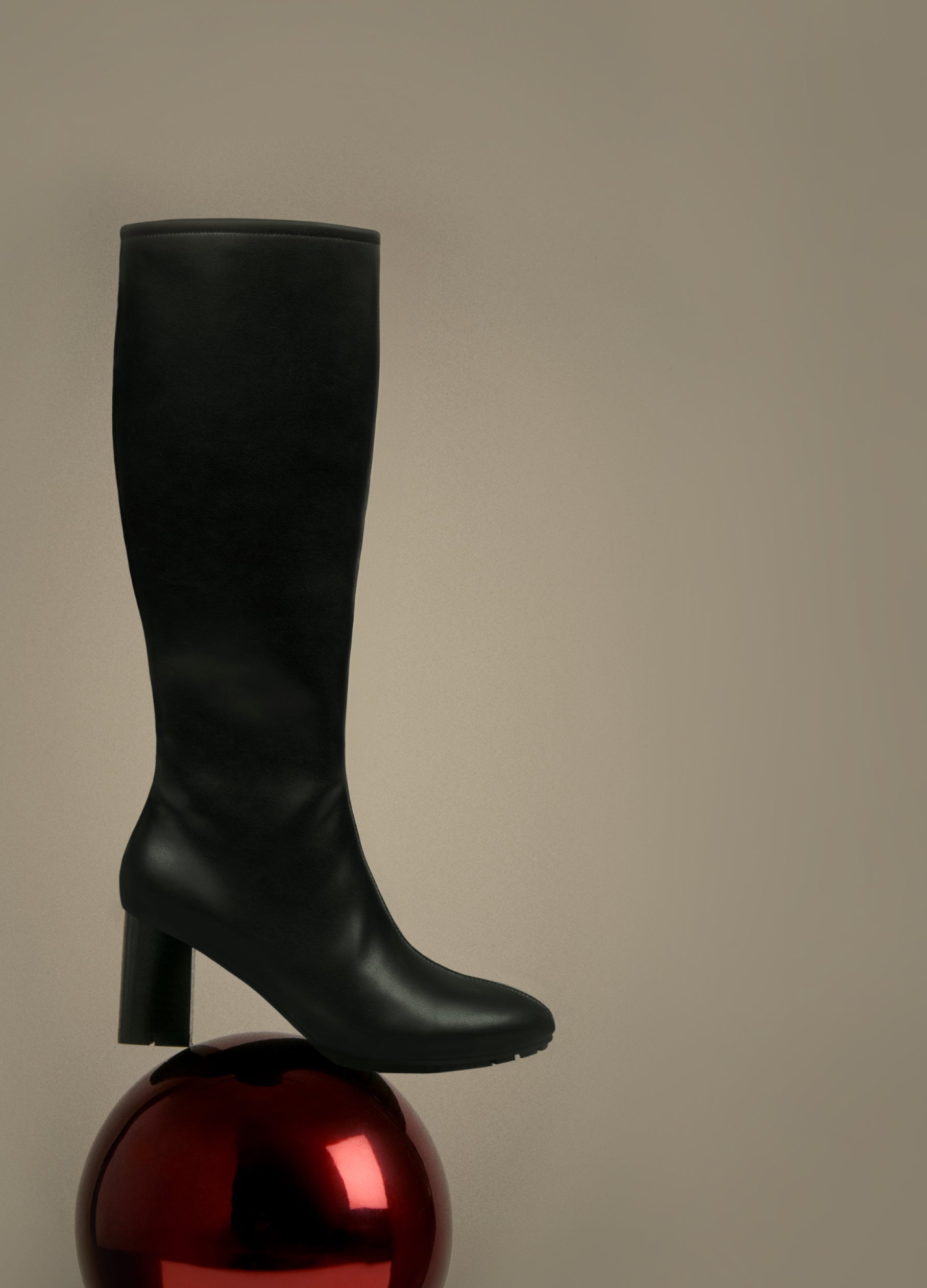 Black knee-high boot on a reflective surface with a neutral background. the holiday countdown. up to 40% off sitewide. excludes new arrivals. shop now